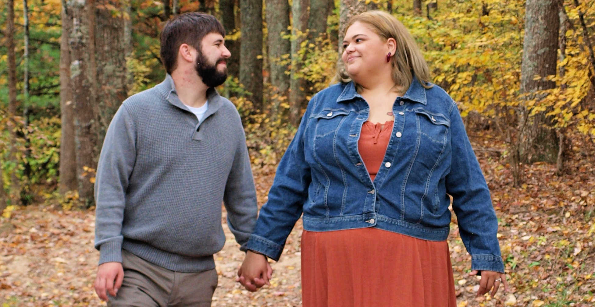 Engaged couple walking in woods